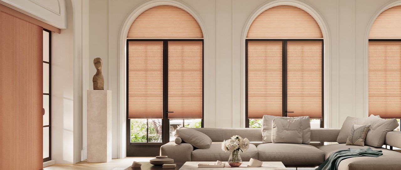 Large living room with tall windows featuring Duette® Honeycomb Shades Fabric: Elan®  Color: Cider 